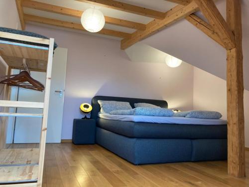 a bedroom with a blue bed and a ladder at Saarburg Wine Apartments in Saarburg