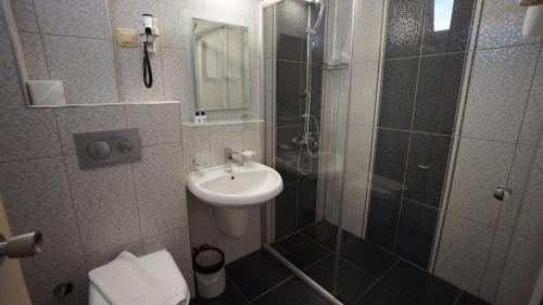 a bathroom with a shower and a sink at Kleopatra Balik Hotel in Alanya