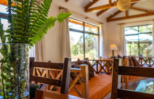 a dining room with a table and a vase with a plant at Black Wattle House in Nakuru