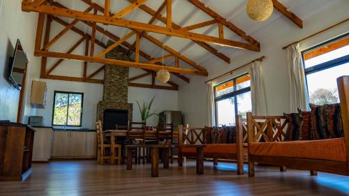 a living room with a table and chairs and a fireplace at Black Wattle House in Nakuru