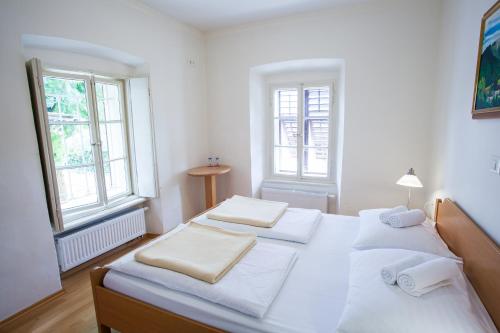 a bedroom with a white bed and white walls at B&B Pod Skalo in Kamnik