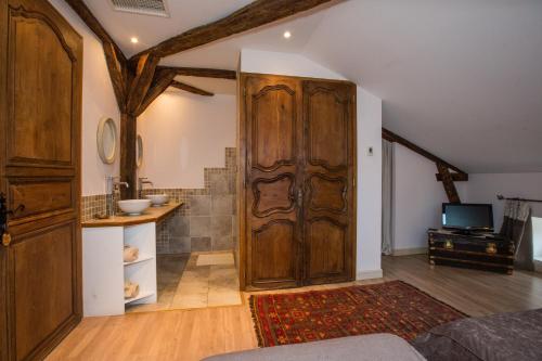 Zimmer mit einer großen Holztür und einem TV in der Unterkunft Chambre d'Hôtes Bastide du Cosset in Barcelonne-du-Gers