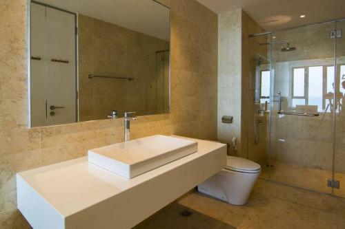 uma casa de banho com um lavatório, um WC e um espelho. em Jazz 313 Cosy 2-Bedroom Suite with Pool & Seaview em Bagan Jermal