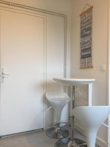 une chambre avec une table et deux tabourets blancs dans l'établissement Studio 3 cosy au dernier étage, à Lorient