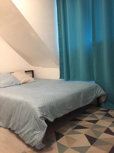 - une chambre avec un lit doté d'un rideau bleu dans l'établissement Studio 3 cosy au dernier étage, à Lorient