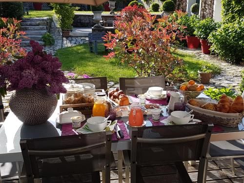 einen Tisch mit Frühstückszutaten darauf in einem Garten in der Unterkunft Les Glycines in Ury