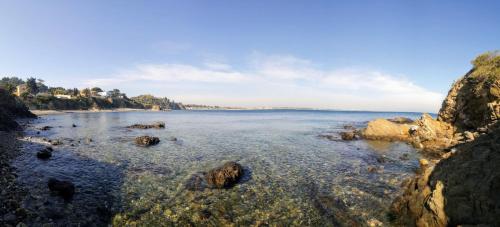 a large body of water with rocks in the water at Agréable studio bord de mer in Saint-Cyprien