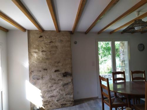 une salle à manger avec un mur en pierre dans l'établissement Au Fil de l'Eau, à Le Boupère