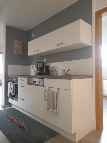 a kitchen with white cabinets and a sink at FeWo Karola in Ellenz-Poltersdorf
