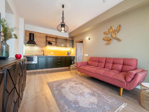 a living room with a red couch in a kitchen at Signature Aparthotel - Boutique in Galaţi