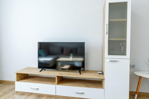 a living room with a television on a table at Баня Аква Ризорт in Banya
