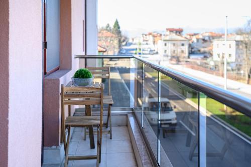 a balcony with two chairs and a plant on it at Баня Аква Ризорт in Banya