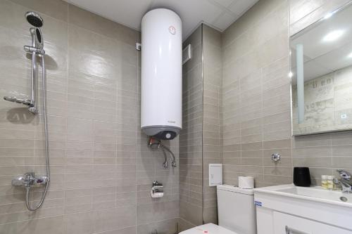 a bathroom with a shower and a toilet and a sink at Баня Аква Ризорт in Banya