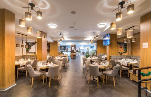 a dining room with tables and chairs and lights at St George Ski & Holiday - Half Board & All Inclusive in Bansko