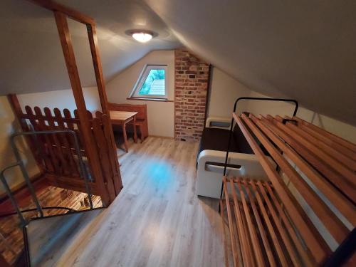 um quarto no sótão com uma cama e uma mesa em Na Pograniczu domek w górach em Lasowka