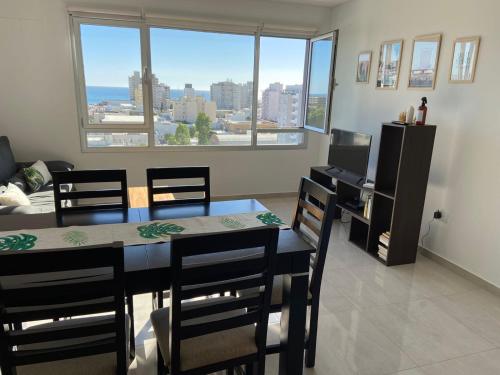 a dining room with a table and chairs and a window at Departamento con vista al mar in Puerto Madryn