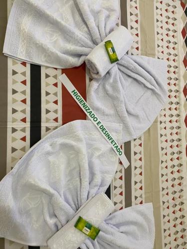 a pile of white towels with a toothbrush in them at Pousada Nova Estrela da Canastra in Delfinópolis