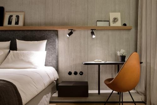 a bedroom with a bed and a table and a chair at Hôtel National Des Arts et Métiers in Paris