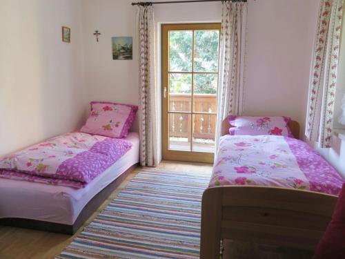 Duas camas num quarto com uma janela em Ferienwohnung Aiblinger em Frasdorf
