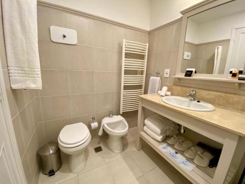 a bathroom with a toilet and a sink at Serena Hotel - Punta del Este - Unico sobre la Playa in Punta del Este