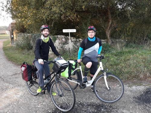 two men sitting on their bikes on a road at Manoir du Bois Joly - Roulotte Art Déco in Margon