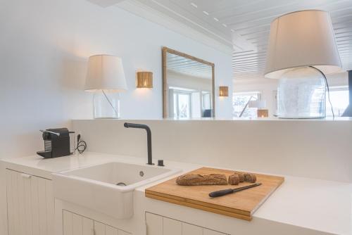 a white kitchen with a sink and a mirror at Villa Sublime in Colares