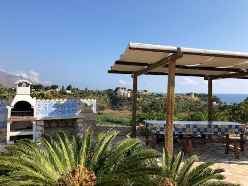 a patio with a table and a pizza oven at Scopello Guidaloca Villas in Scopello