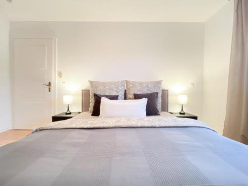 una camera con un grande letto con due lampade di Apartment Mozart a Gernsbach