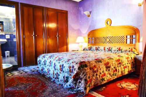 een slaapkamer met een bed met een kleurrijke sprei bij Hôtel Transatlantique in Casablanca