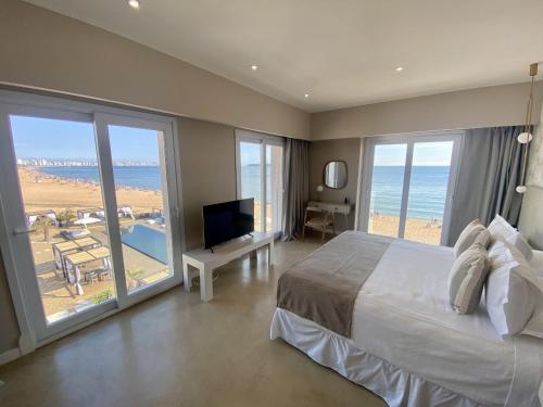a bedroom with a bed and a view of the ocean at Serena Hotel - Punta del Este - Unico sobre la Playa in Punta del Este