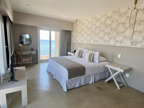 a bedroom with a bed and a view of the ocean at Serena Hotel - Punta del Este - Unico sobre la Playa in Punta del Este