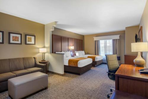 a hotel room with two beds and a couch at Comfort Suites Marshall in Marshall