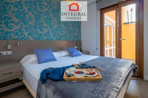 a bed with a tray of food on it at Palamós Luxe Apartments in Palamós