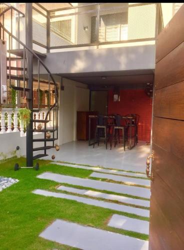 a patio with a table and chairs and grass at Alimama Guesthouse Melaka with Balcony in Melaka