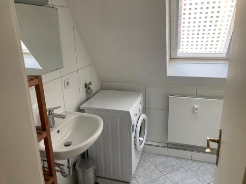 ein kleines Bad mit einem Waschbecken und einer Waschmaschine in der Unterkunft Alte Brücke in Heidelberg
