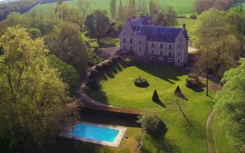 einen Luftblick auf ein großes Haus mit einem Pool in der Unterkunft l'Abeaupinière in Reboursin