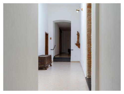 an empty hallway with a door and a stairway at Monastero Santa Chiara CpF in Oristano