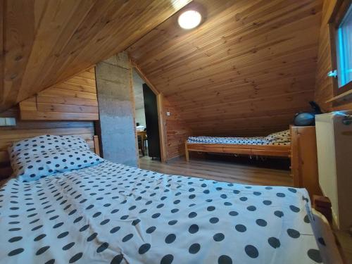 a bedroom with a bed in a wooden cabin at Apartament Ruska Bania Na Pograniczu in Lasowka