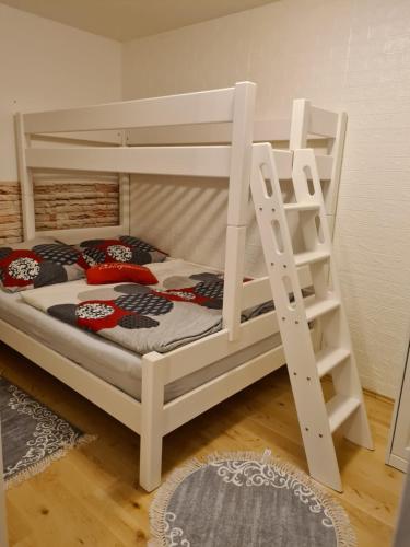Litera blanca con escalera en una habitación en Wohnung im Grünen, en Fürth