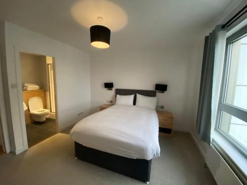 a bedroom with a white bed and a window at Britannia Apartments in Edinburgh