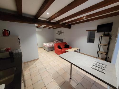 ein Wohnzimmer mit einem roten Sofa und einem Tisch in der Unterkunft Le petit monas in Civaux