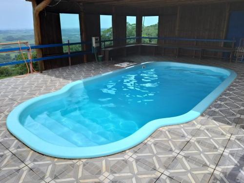 a large blue swimming pool on a patio at Pousada do Belvedere - Sítio Ramos in Praia Grande