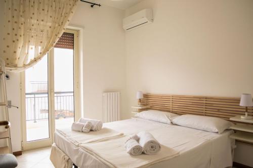 ein Schlafzimmer mit einem großen weißen Bett mit Handtüchern darauf in der Unterkunft Cà del Mar in Polignano a Mare