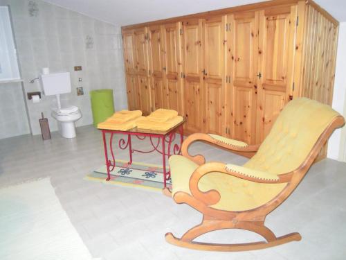 ein Badezimmer mit einem Stuhl und einem Tisch mit einem WC in der Unterkunft I Pettirossi in Frabosa Sottana