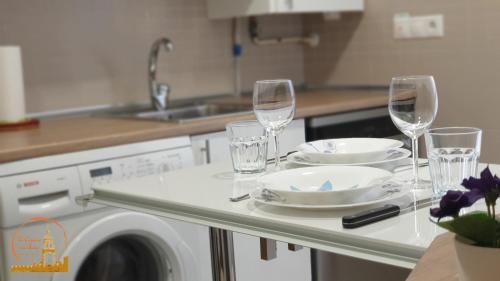 a kitchen with a table with wine glasses and plates at EL CAPRICHO DEL BURGO in El Burgo de Osma