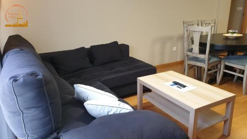 a living room with a blue couch and a table at EL CAPRICHO DEL BURGO in El Burgo de Osma
