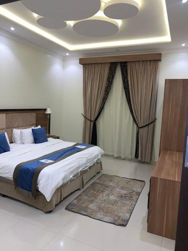 a bedroom with a large bed and a large window at Elite Furnished Units in Riyadh
