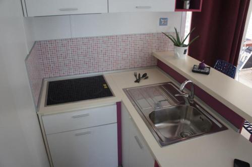 una piccola cucina con lavandino e piano di lavoro di GARDENIA a Biograd na Moru