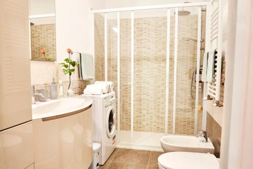 Baño blanco con lavadora y secadora en Casa Iris Panzano in Chianti, en Pieve di Panzano