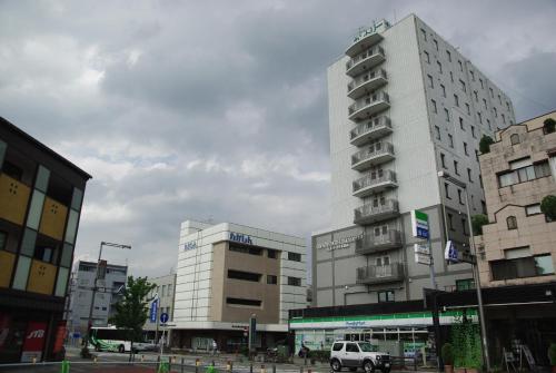a tall white building in the middle of a city at Country Hotel Takayama in Takayama